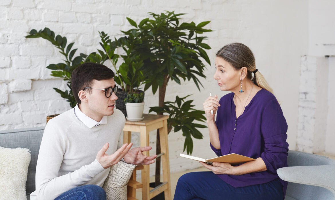 psychology therapy psychiatry mental health counseling concept candid shot nervous self conscious young male glasses telling middle aged female counselor about his problems work